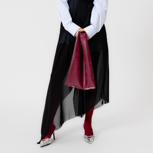 MERLOT red wine latex bag shaped like a classic plastic shopping bag with sculptural cutout handles by Dorilou